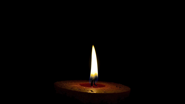 Flame burning on a single candle.