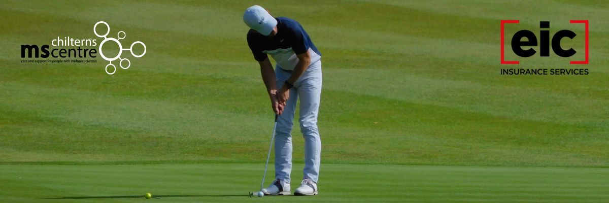 Golfer on the green preparing to putt the ball.
