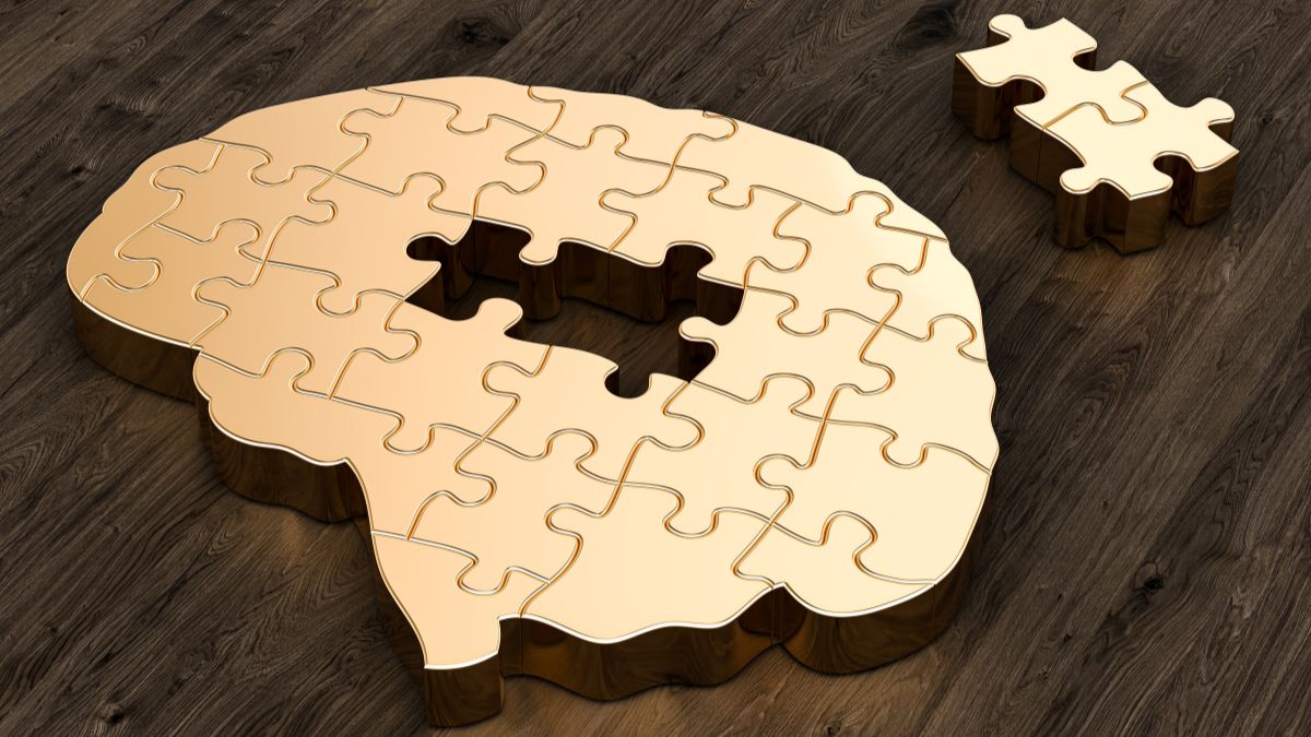 Jigsaw puzzle in the shape of a brain with two pieces missing.